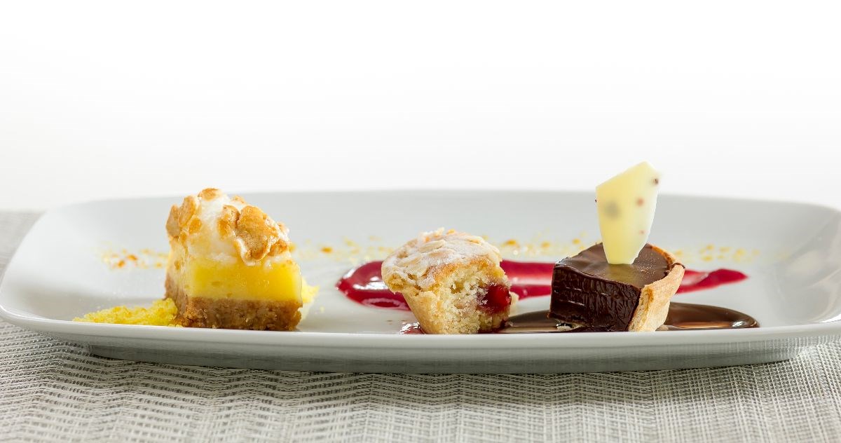 Example of a dessert. Trio of chocolate tart, lemon meringue, raspberry and almond tart