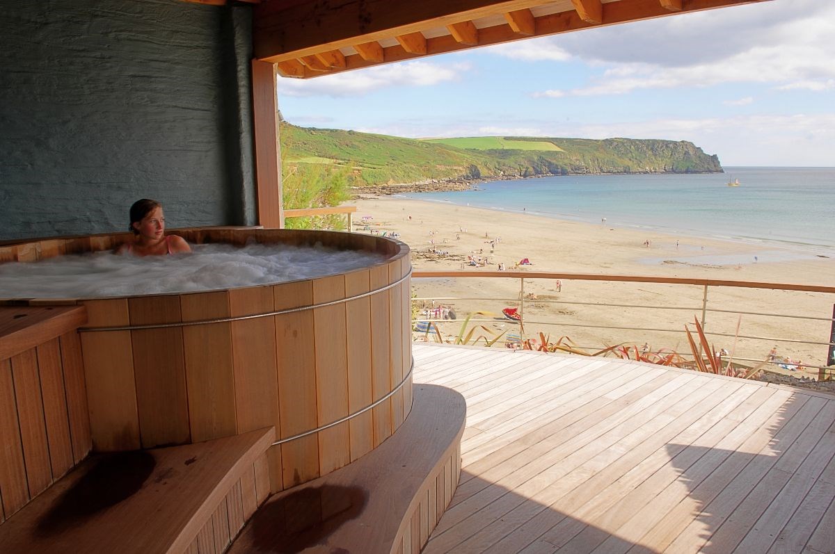 A sheltered hot tub enjoys commanding views over the beach