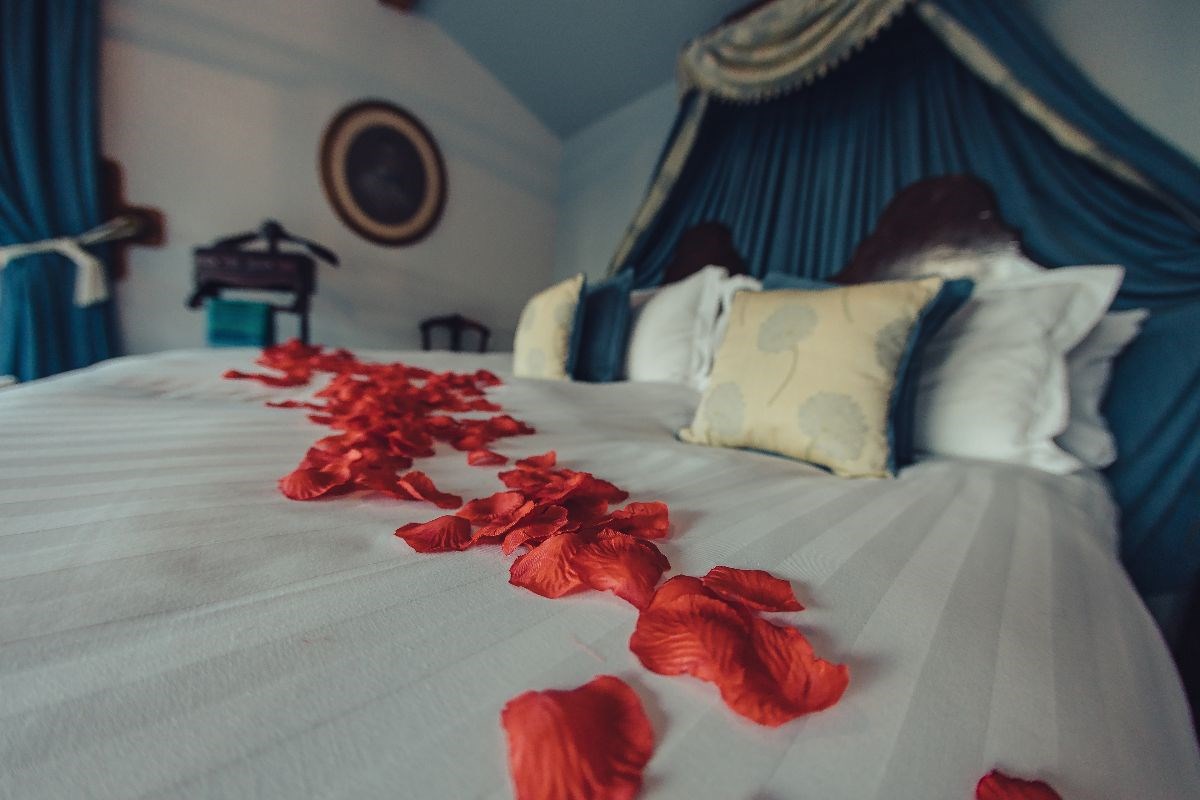 Rose petals on arrival in the large antique canopied bed