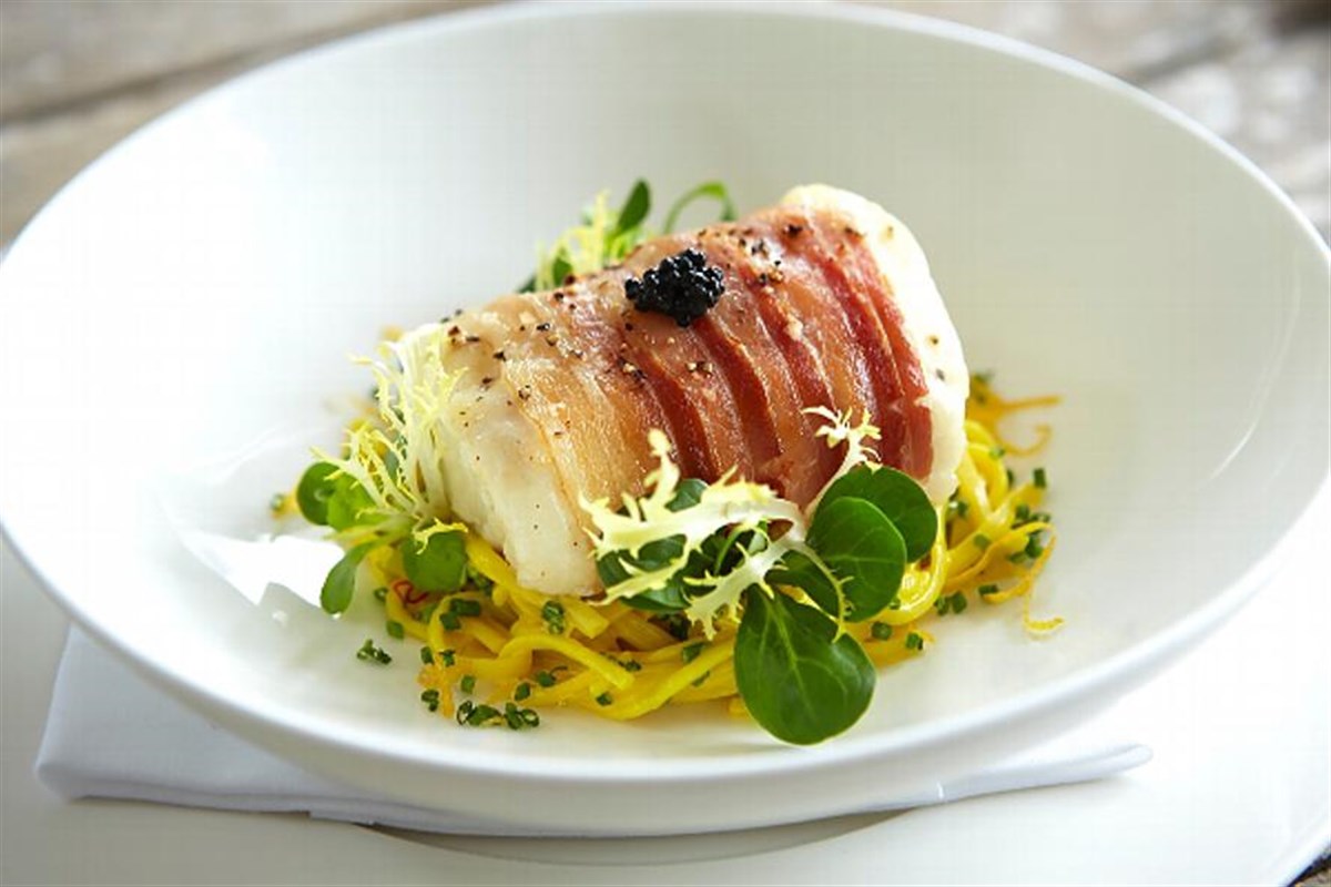 Pancetta wrapped Atlantic cod on a bed of saffron linguini