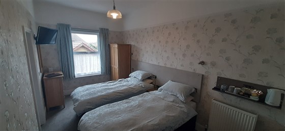 Habitación doble con baño y sillas cómodas