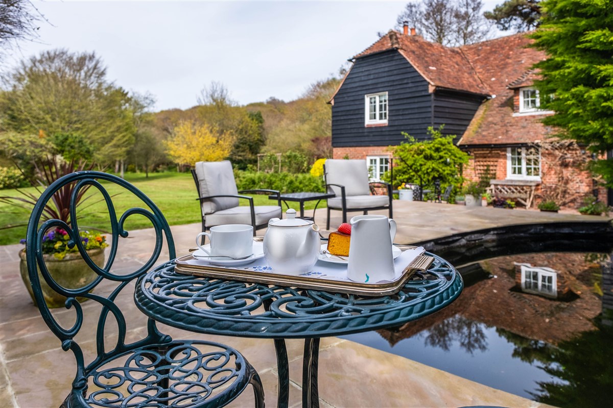 Complimentary tea and cake by the pond on arrival in summer