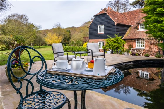 Complimentary tea and cake by the pond on arrival in summer