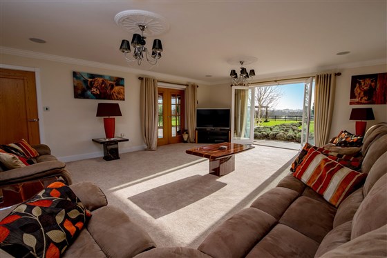 A sumptuous and spacious living room, with doors onto the garden